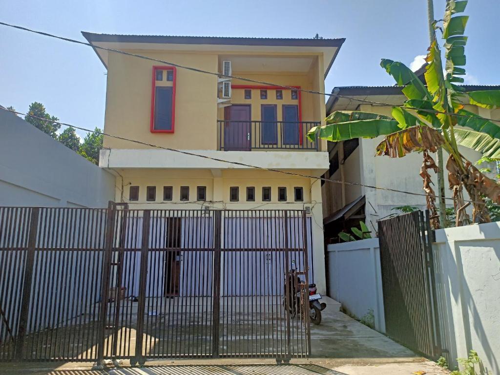 een huis met een hek ervoor bij OYO 93073 Penginapan 69 in Jayapura