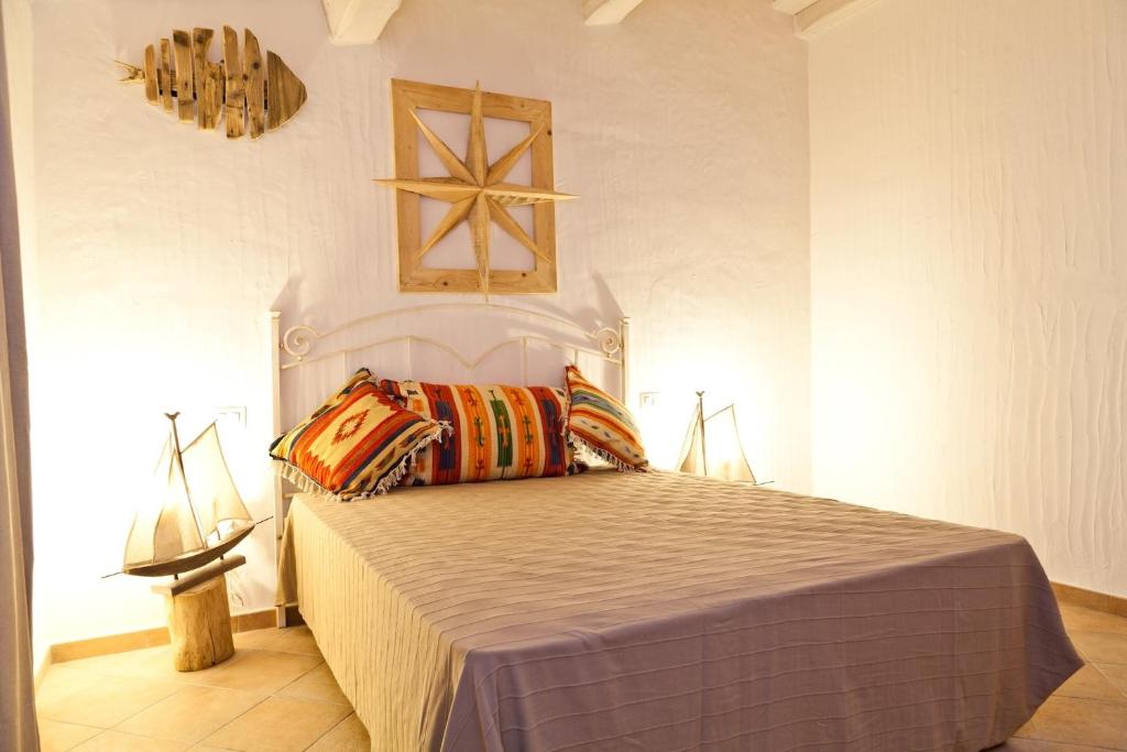 ムルタ・マリアにあるSmart Appart Cosy Sardiniaのベッドルーム1室(カラフルな枕付きのベッド1台付)