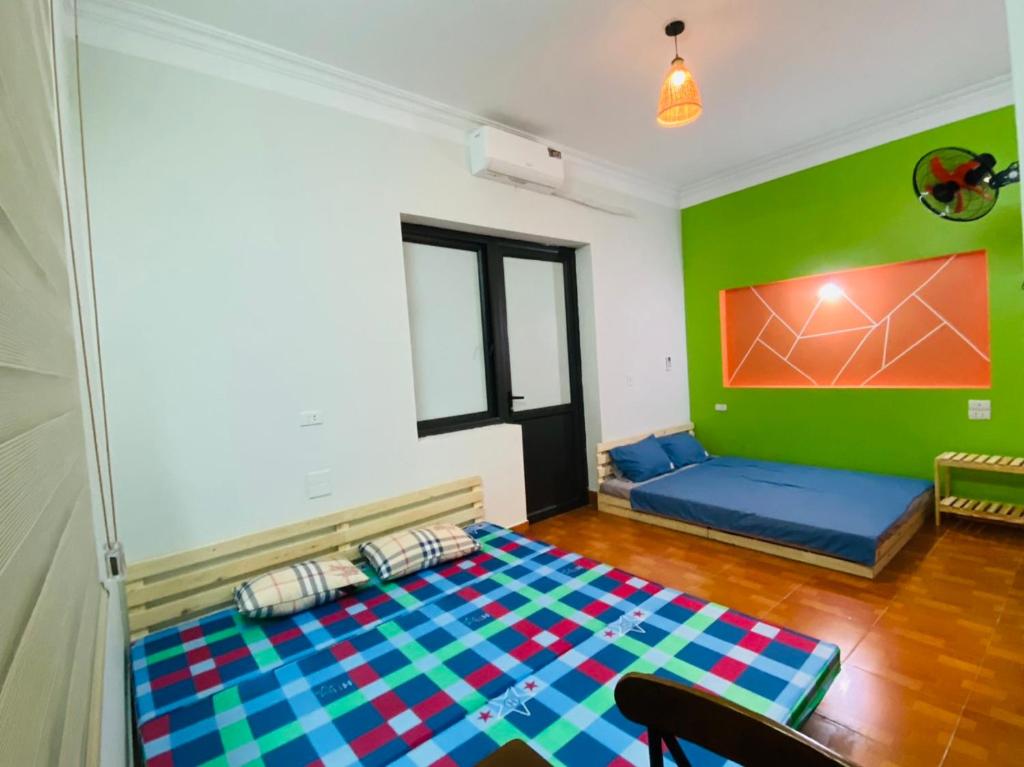 una camera con un letto e una parete verde di Lion homestay a Ða Gia