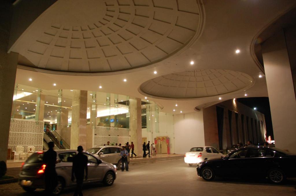 ein Gebäude mit Autos auf einem Parkplatz in der Unterkunft Hotel Grand Canyon in Raipur