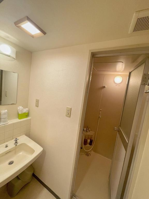 a bathroom with a shower and a sink at Sakura Hotel Ikebukuro in Tokyo