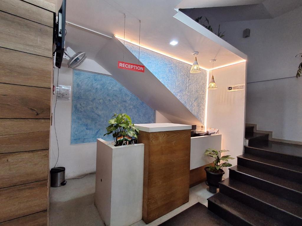 a staircase in a building with a lobby with potted plants at Sharp Suites in Ernakulam