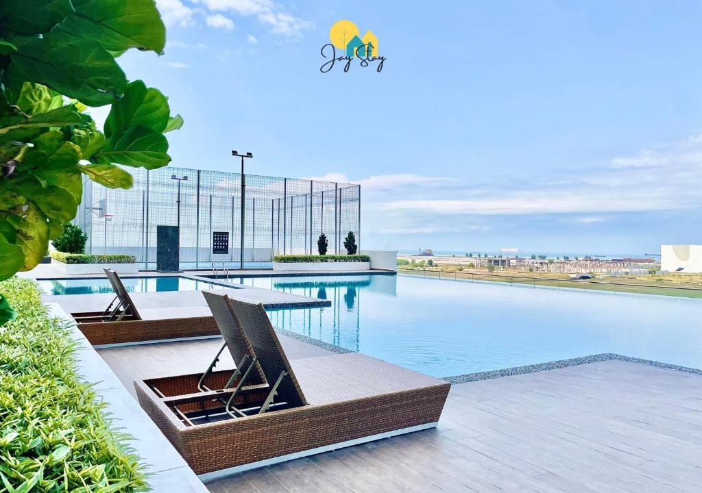 a swimming pool with a table and chairs on top of it at Amber Cove l Luxury Seaview 2BR l 6-8pax l GamesRoom l City Centre l Jonker St by Jay Stay in Melaka