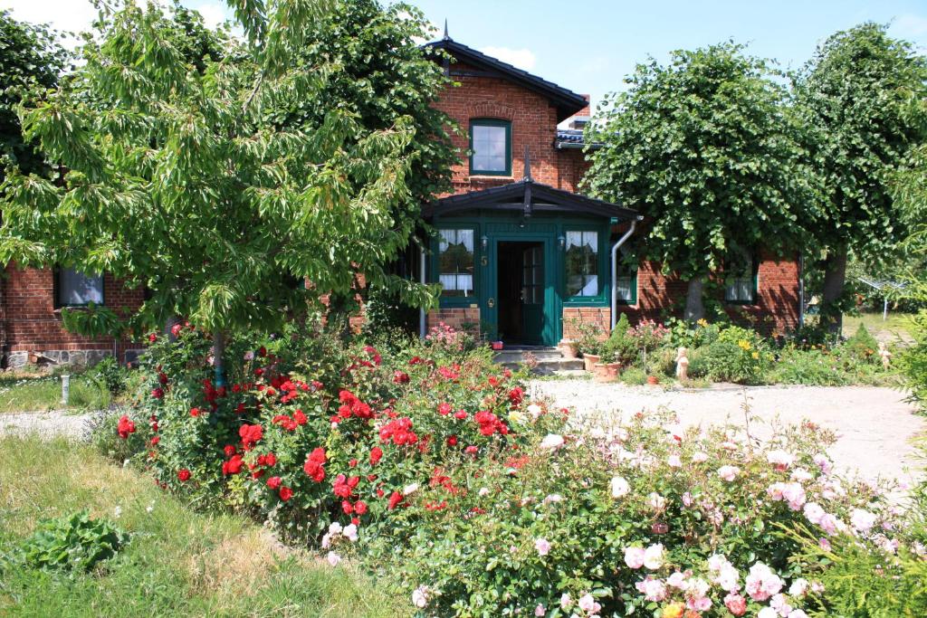 una casa con un jardín de flores delante de ella en Landhaus Questin, en Alt Bukow