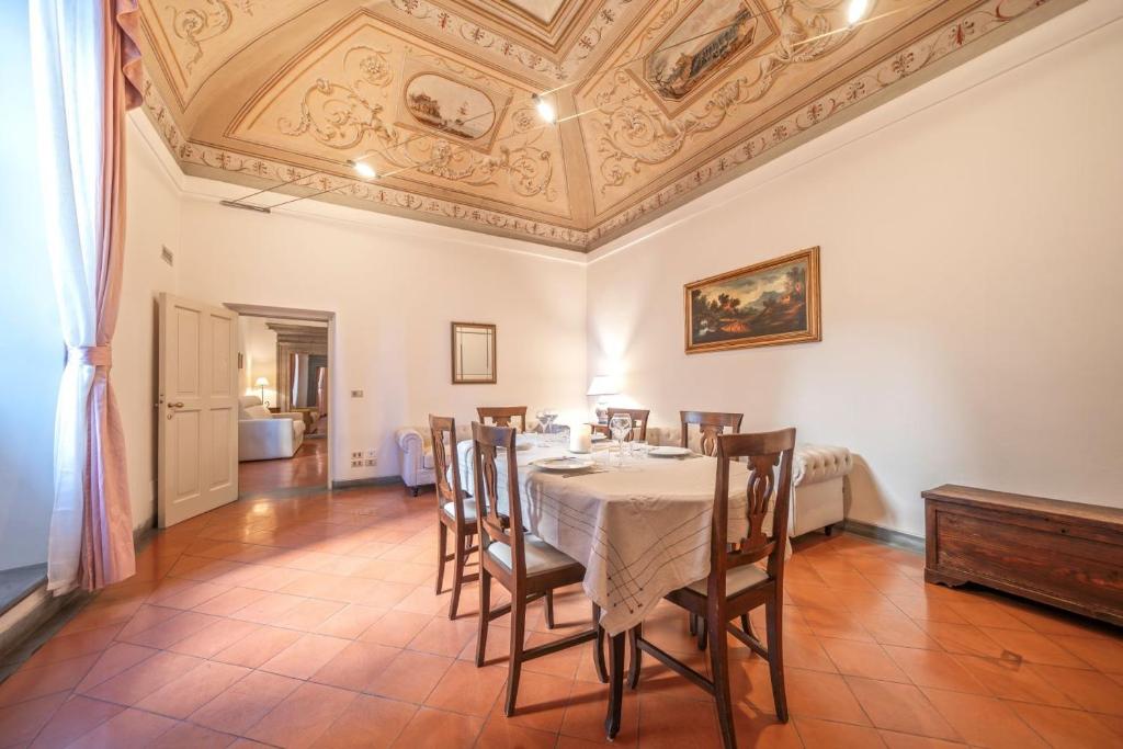 a dining room with a table and chairs and a ceiling at Raffaello - M&M Holiday House in Perugia