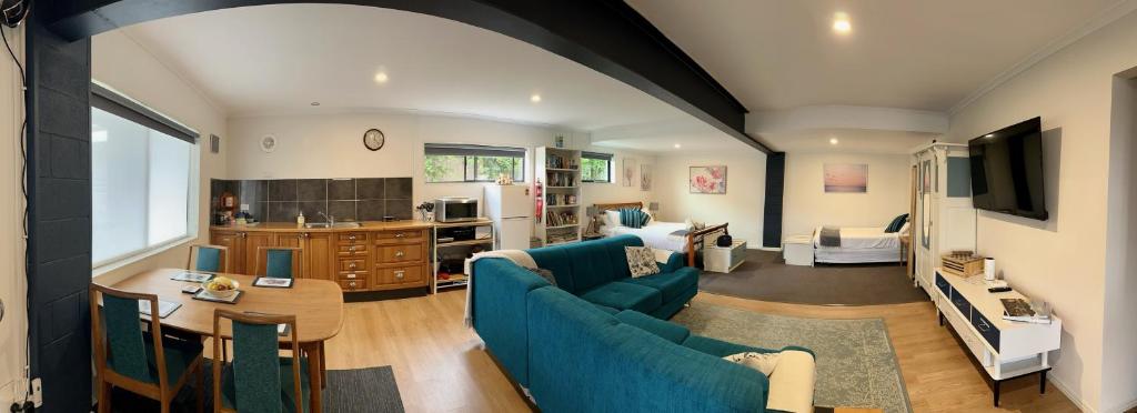 sala de estar con sofá azul y mesa en GOLDFIELDS STUDIO APARTMENT, Beaconsfield - Fully Self-contained, air-conditioning en Beaconsfield
