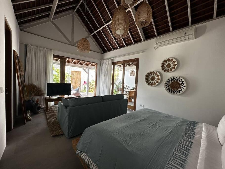 Deluxe 1 Sula villa in uluwatu في أُلُواتو: غرفة معيشة مع سرير وأريكة