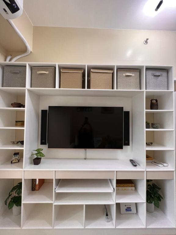 a white entertainment center with a television on it at * * L Iloilo's Quirky Oasis in Iloilo City