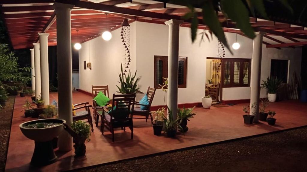 a patio with chairs and potted plants at The Villa Hush in Hikkaduwa