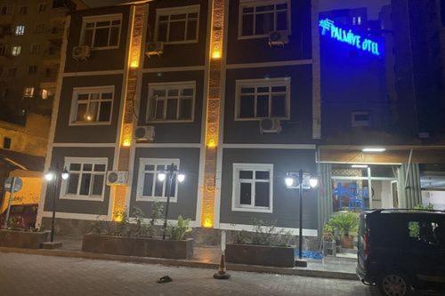 un edificio con una señal azul en el costado. en Asus Palmiye Otel, en Adana