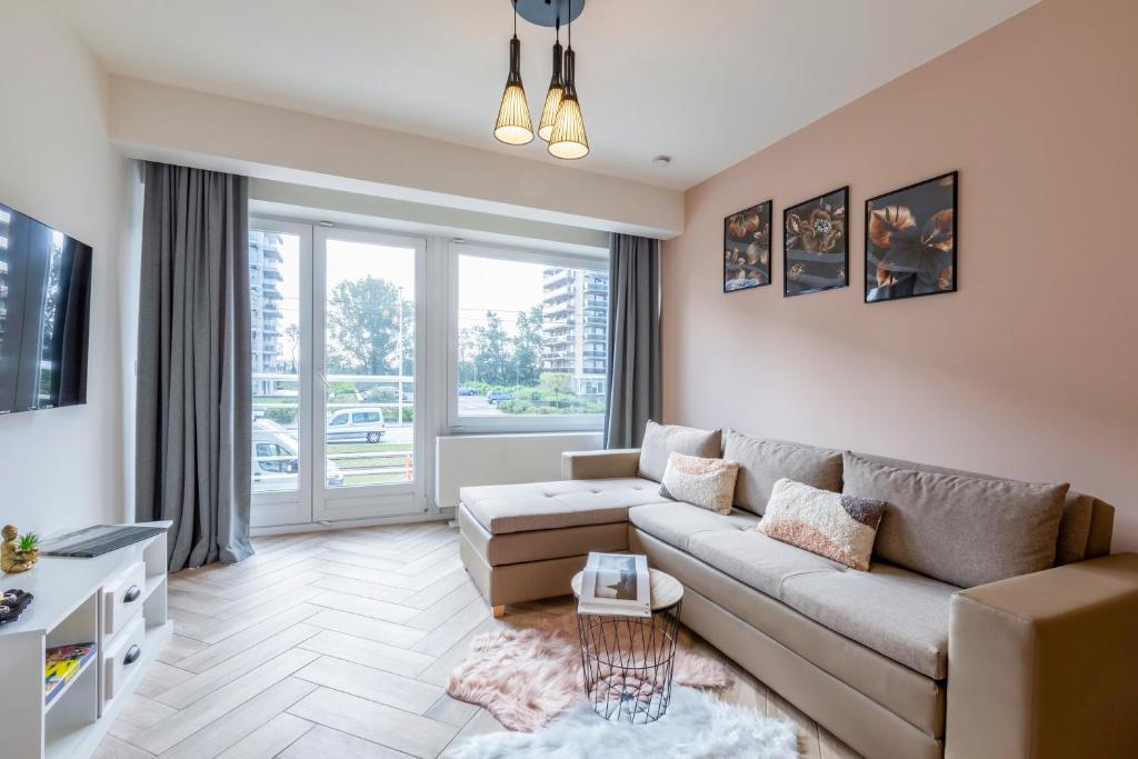 sala de estar con sofá y ventana grande en EVA-Modern 2 bedroom apartment seaside Oostende en Ostende