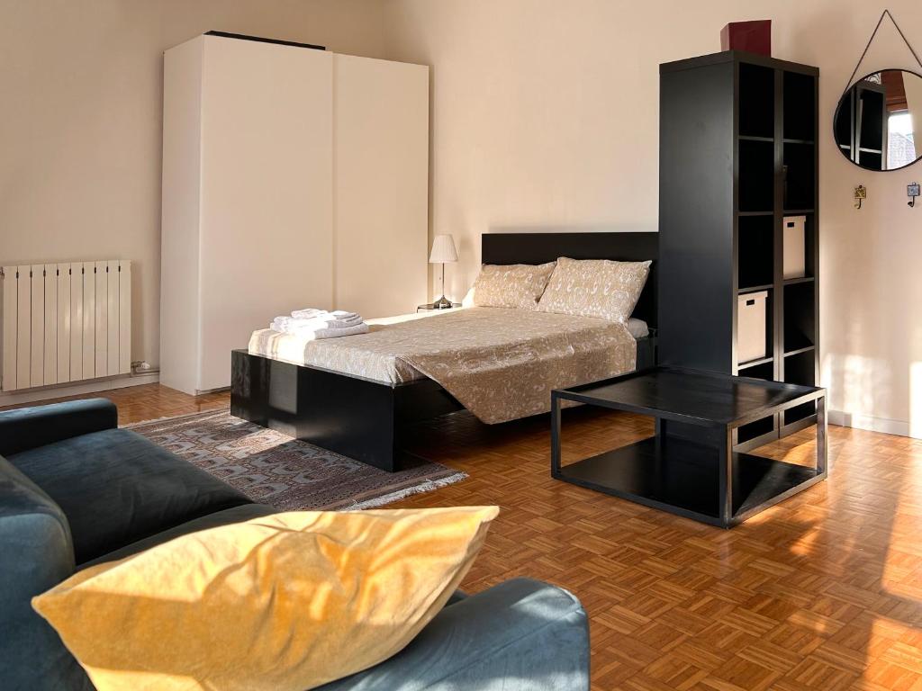 uma sala de estar com uma cama e um sofá em Easy Isola, for an easy stay em Milão