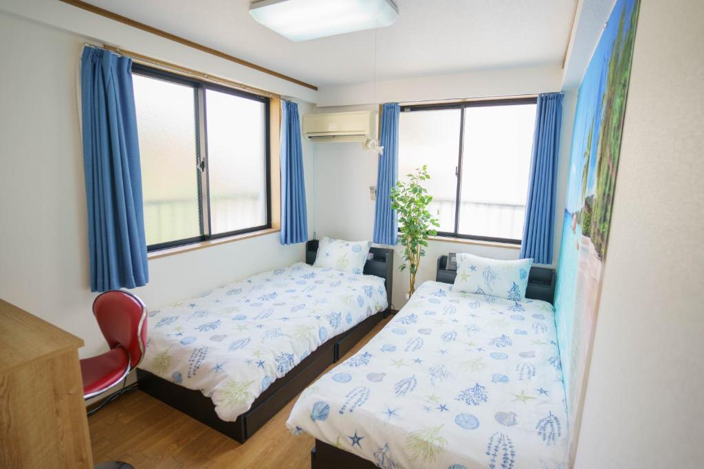um quarto com 2 camas e 2 janelas em BURan House em Tóquio