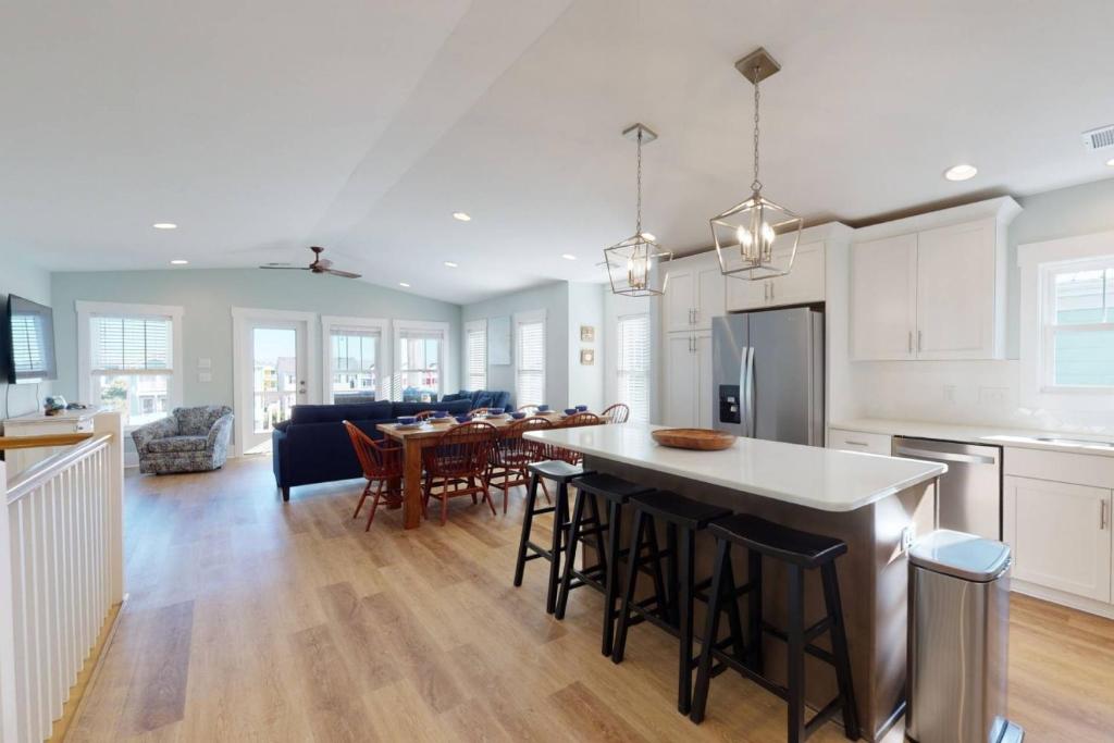 a kitchen and living room with a table and chairs at Happily Ever After! in Kure Beach