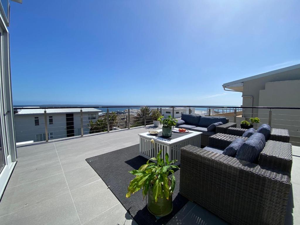 a patio with couches and a table on a balcony at Ocean View Villa in Cape Town