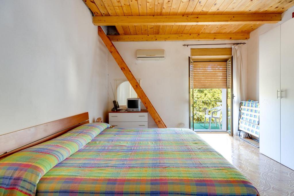 een slaapkamer met een bed met een kleurrijke sprei bij Paradibosa in Bosa