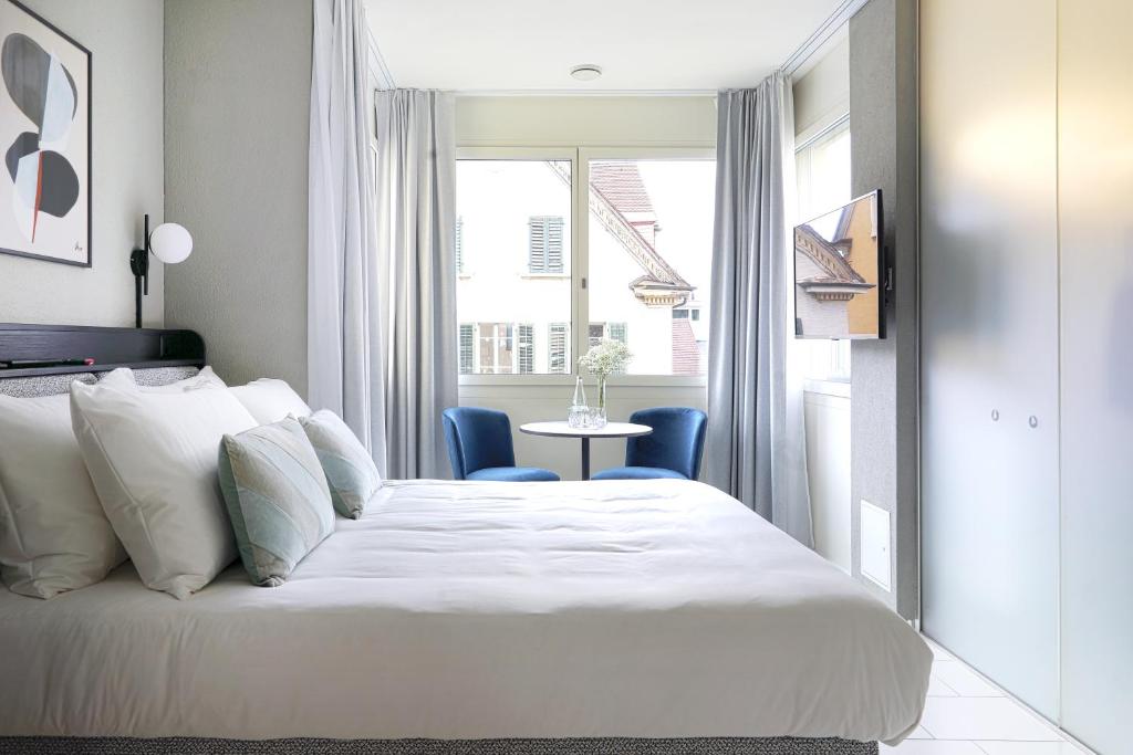 a bedroom with a bed and a table and a window at numa I Turi Apartments in Zurich