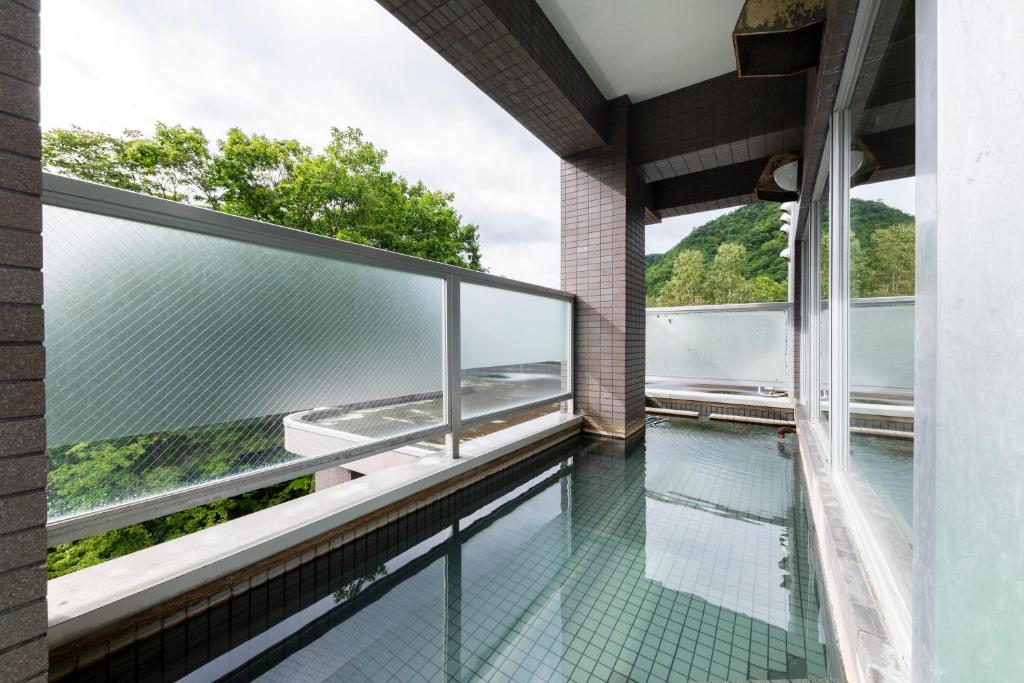 a glass balcony with a view of the water at Few Days Condominium 205 in Jozankei