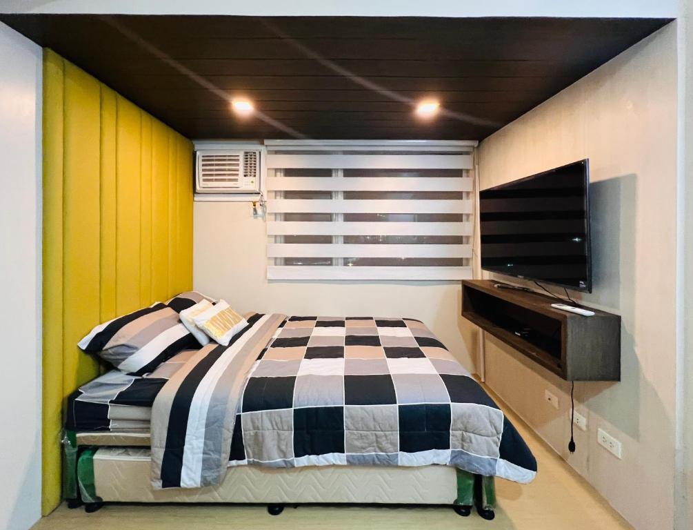 a bedroom with a bed and a flat screen tv at * *R Metropolitan Mirage in Iloilo City