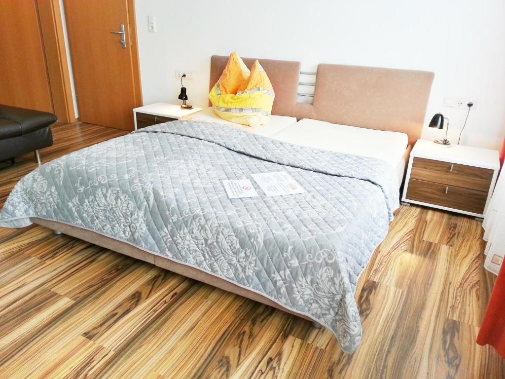1 dormitorio con 1 cama y suelo de madera en Gästehaus zur weißen Rose, en Furth