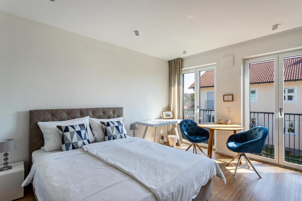Un dormitorio con una cama y dos sillas azules. en Terralpin Apartments - 27qm, en Bruckmühl