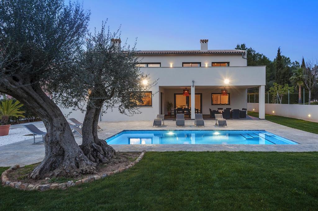 a villa with a swimming pool in front of a house at Villa Lali in Alcudia
