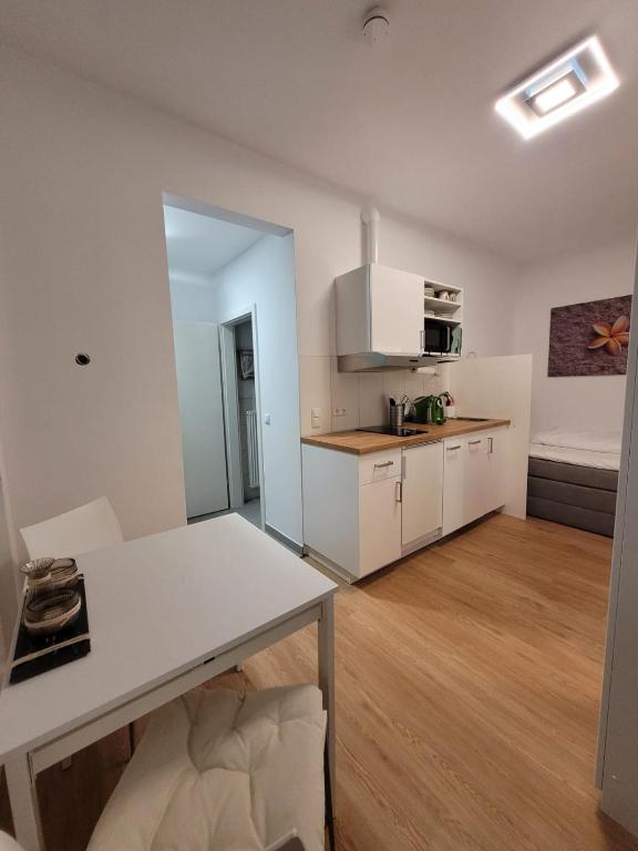 a kitchen and living room with white cabinets and a table at Apartments an der Bühleiche in Plochingen