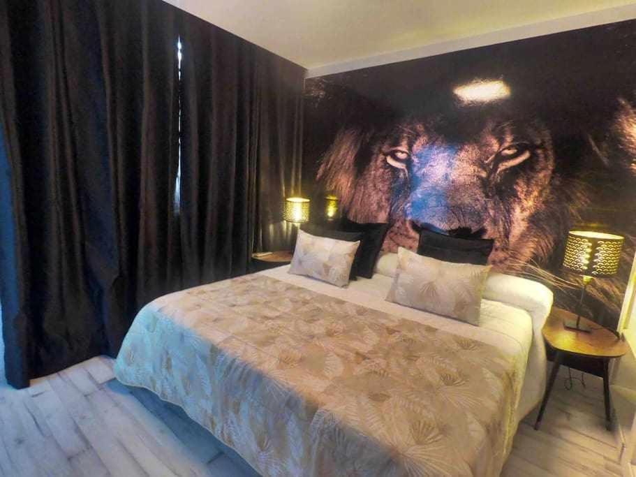 a bedroom with a picture of a lion on the wall at Apartamento con diseño moderno y piscina Taurito in Taurito