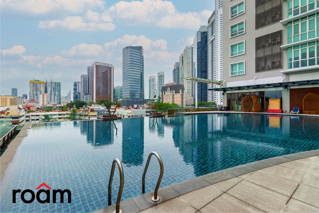 吉隆坡的住宿－Dua Sentral Kuala Lumpur by Roam，一座位于城市的游泳池,有高大的建筑