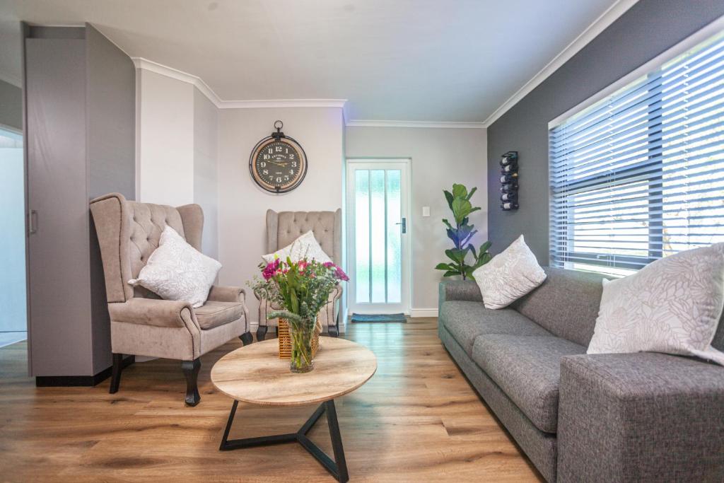 a living room with a couch and a table with flowers on it at @Villa de Vie holiday apartment in Cape Town