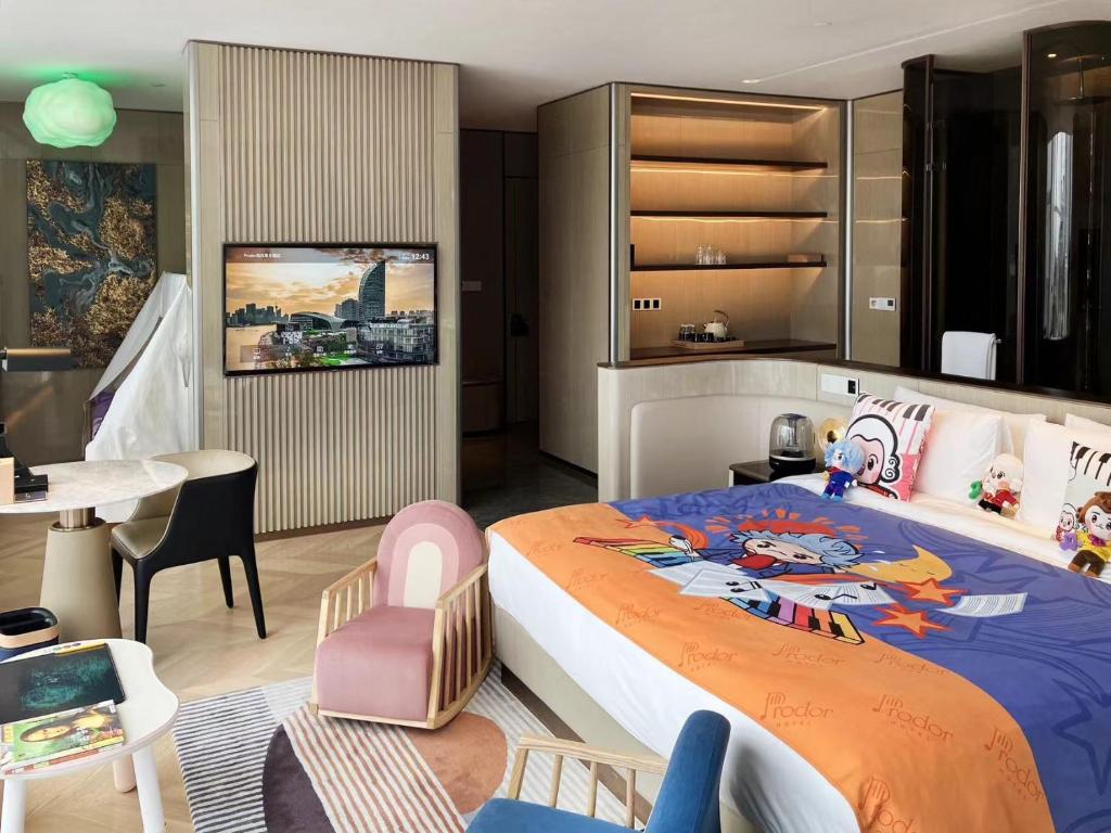 上海市にあるProdor Hotel Shanghaiのベッドルーム1室(大型ベッド1台付)、ダイニングルームが備わります。