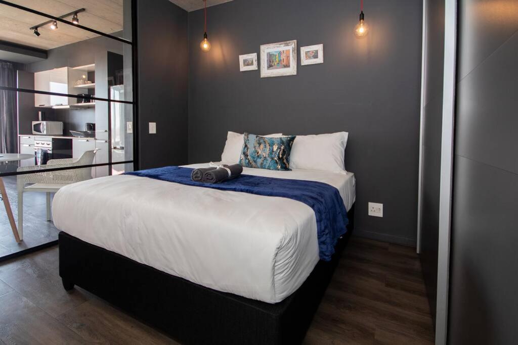 um quarto com uma cama grande e um cobertor azul em Modern Studio in Wex1 538 em Cidade do Cabo
