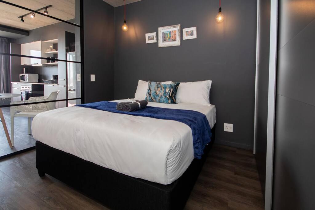 Un dormitorio con una cama grande con una manta azul. en Modern Studio in Wex1 538, en Ciudad del Cabo
