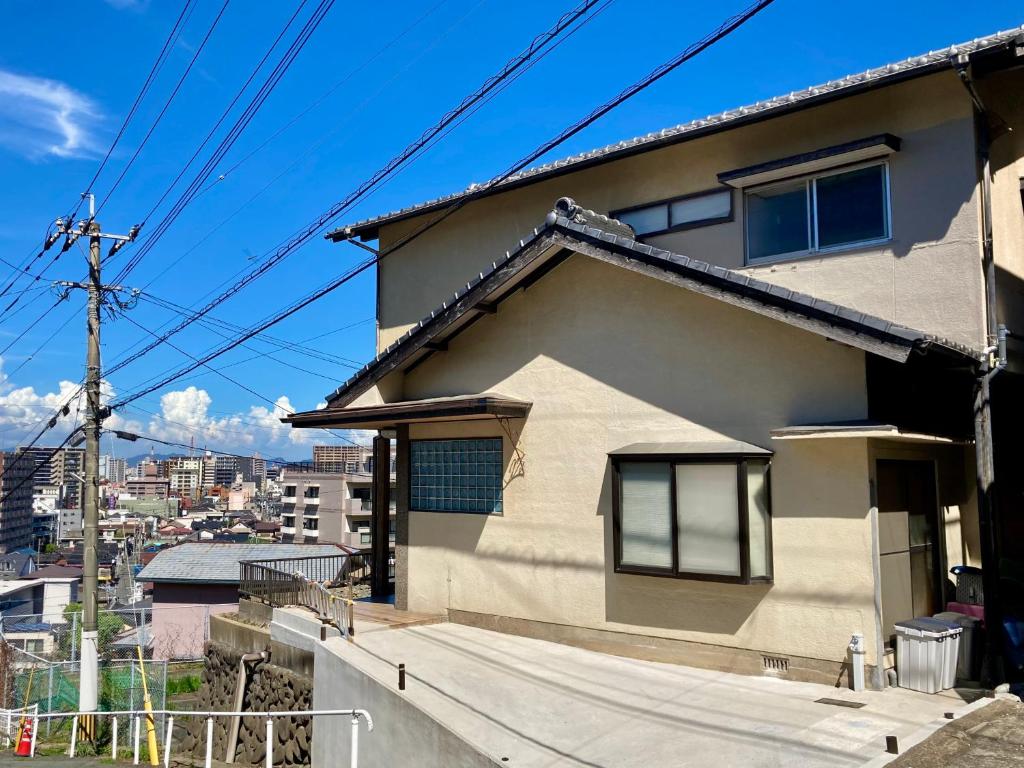 una casa blanca con una cerca al lado en Nostime lodge 女性限定 female only, en Kitakyushu