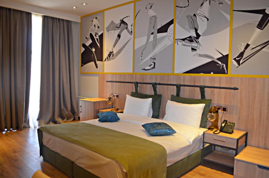 una camera da letto con un grande letto e quadri alle pareti di Arena Sport Hotel a Quba