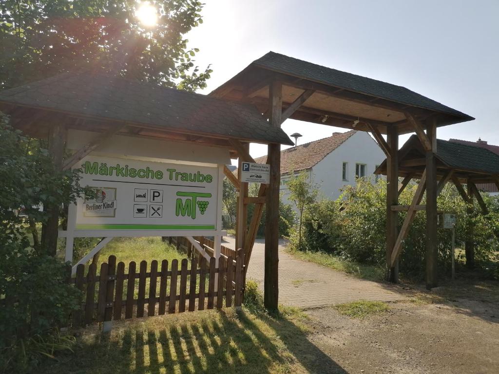 ein Schild vor einem Gebäude mit einem Zaun in der Unterkunft "Märkische Traube" idyllisches Gästehaus für Selbsversorger in Zesch