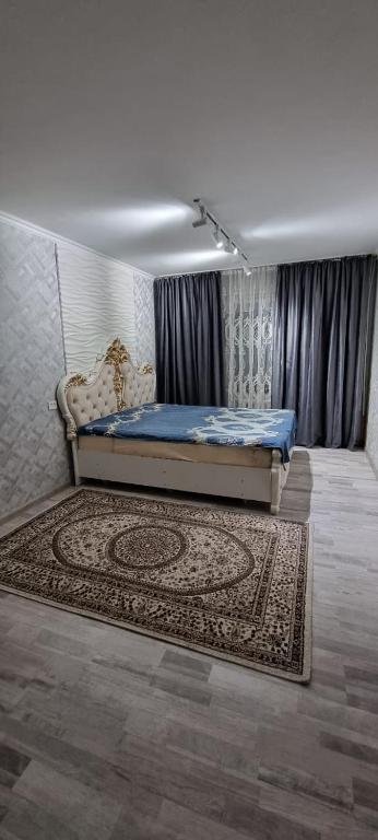1 dormitorio con cama y alfombra en el suelo en 2-комнатная квартира, 55 м², 2/5 этаж посуточно, 8-й микрорайон, 8-й микрорайон 16, en Shymkent
