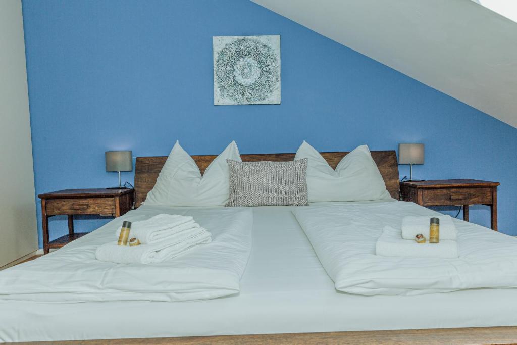 a large white bed with white pillows and a blue wall at arte vida boutique guesthouse in Salzburg