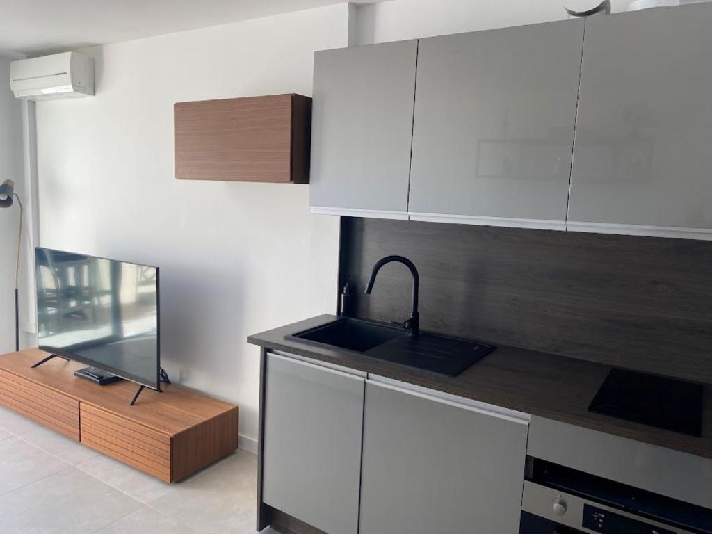 a kitchen with white cabinets and a sink at Appartement T2 Sainte Maxime in Sainte-Maxime
