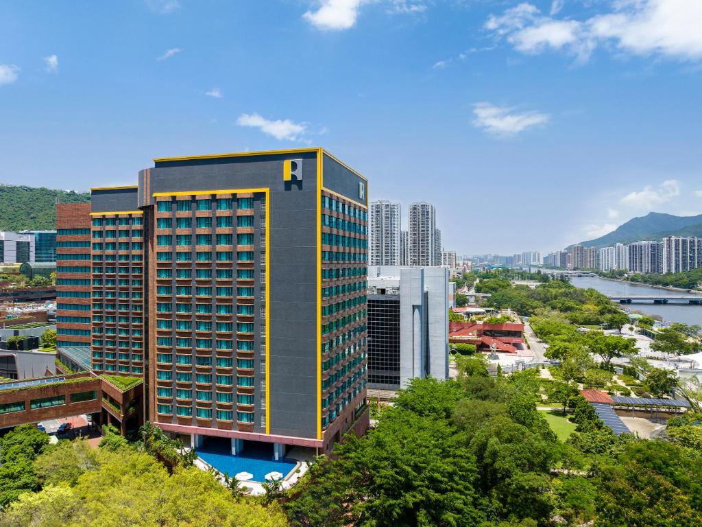 a tall building in a city with trees and buildings at Royal Park Hotel in Hong Kong