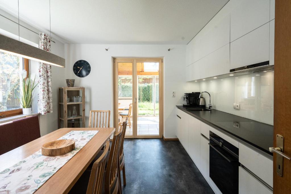 a kitchen with a wooden table and a counter top at Ferienhaus Linde in Bartholomäberg