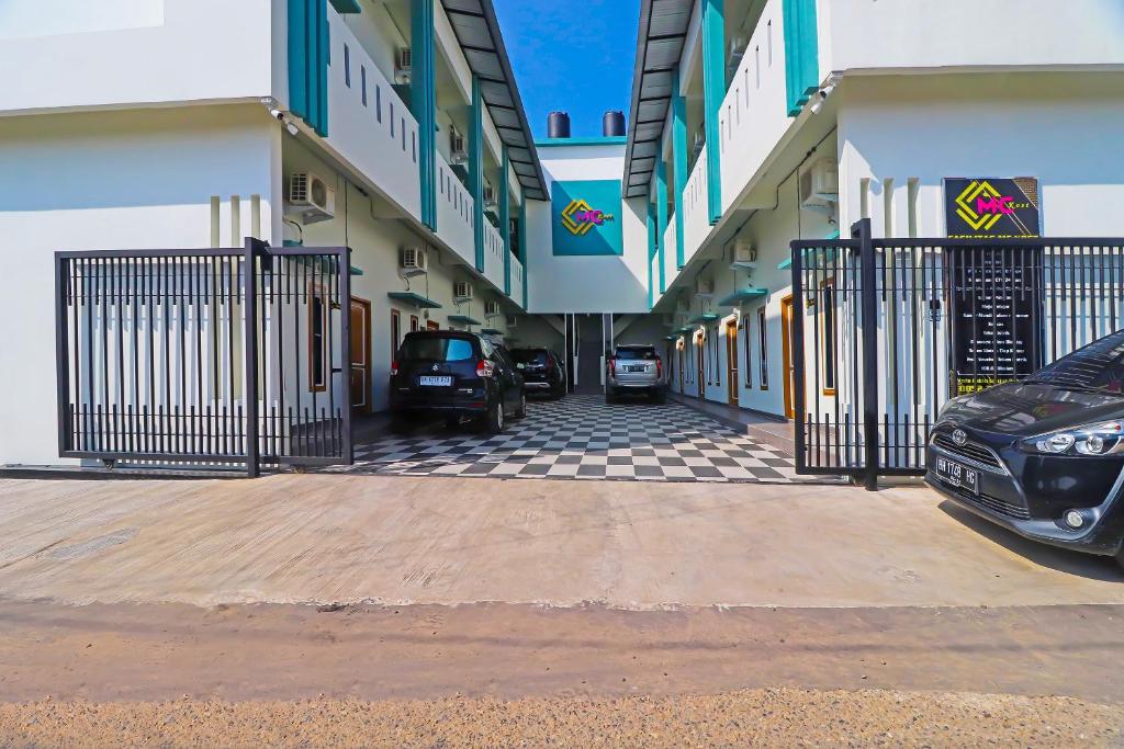 a parking lot with cars parked in front of a building at OYO Life 92691 Mc Kost Syariah in Jambi