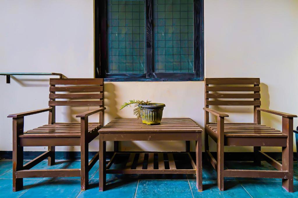 two chairs and a table with a potted plant on it at OYO Life 92641 Guest House Palinggihan Ii in Cirebon