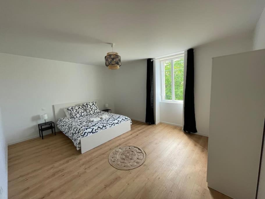 een witte kamer met een bed en een raam bij Maison 6 chambres in Clohars-Carnoët