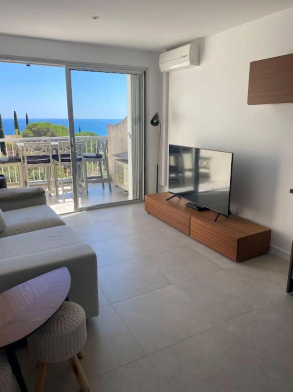 un salon avec une télévision à écran plat et un canapé dans l'établissement Appartement T2 Sainte Maxime, à Sainte-Maxime