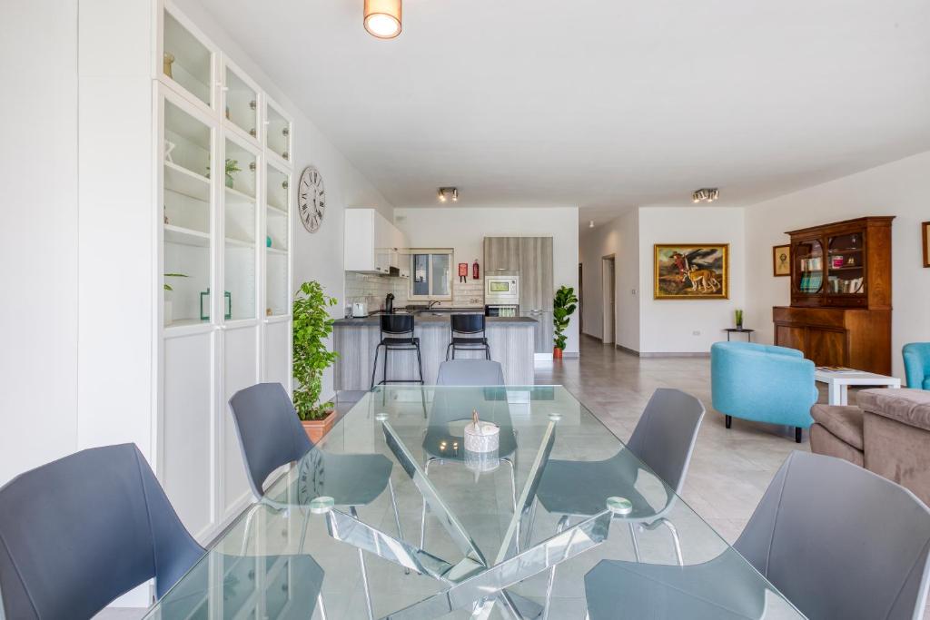 a dining room with a glass table and chairs at Annitchka Mansions - Apartment in central Malta in Birkirkara
