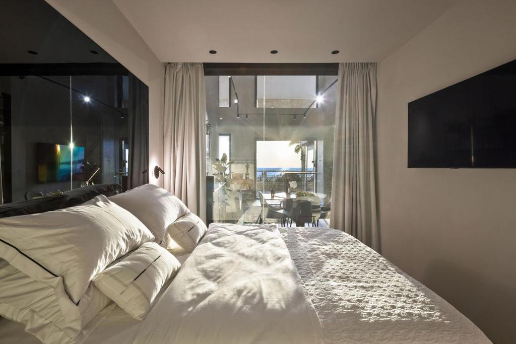 een slaapkamer met een bed en een groot raam bij Samuel TLV in Tel Aviv
