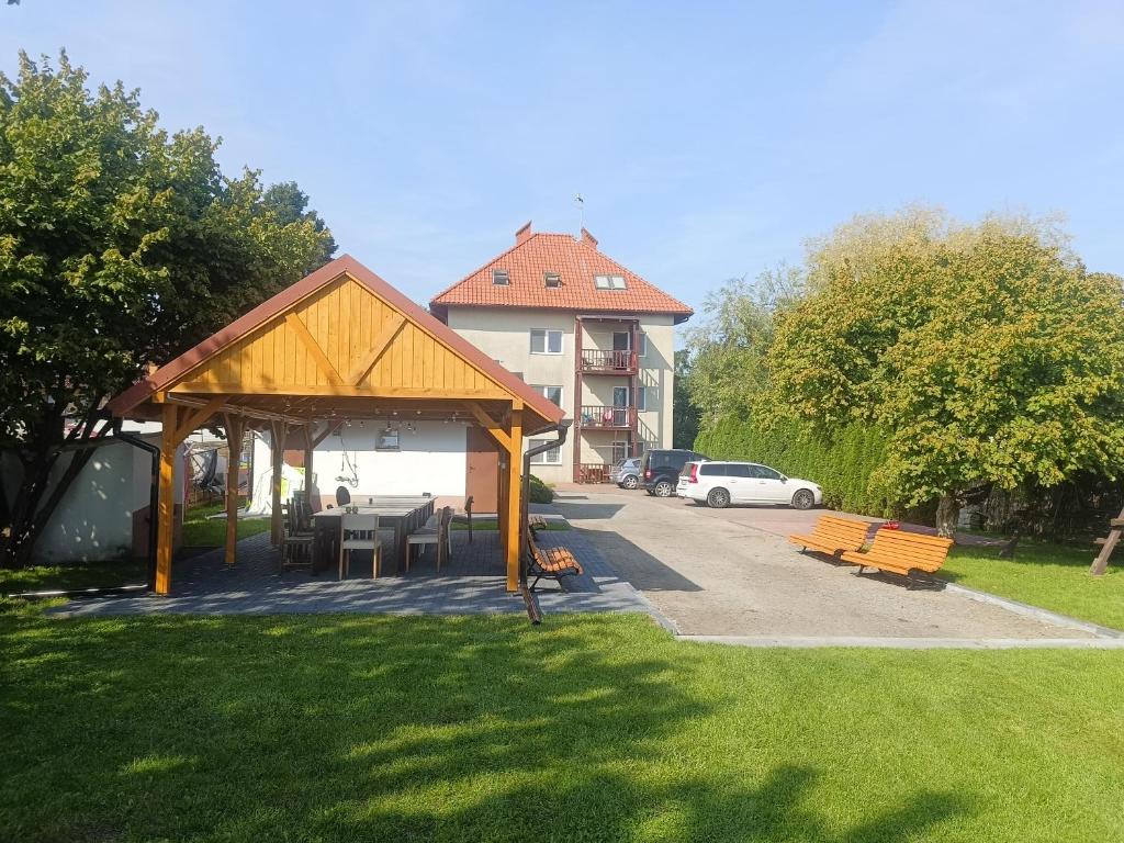 - un pavillon avec une table et des chaises dans un parc dans l'établissement Kraken-pokoje gościnne, à Krynica Morska