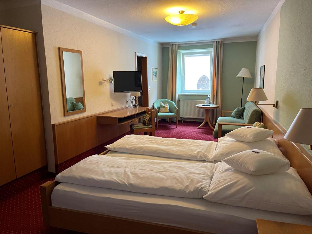 Habitación de hotel con cama grande y TV en Hotel Jungbräu, en Abensberg
