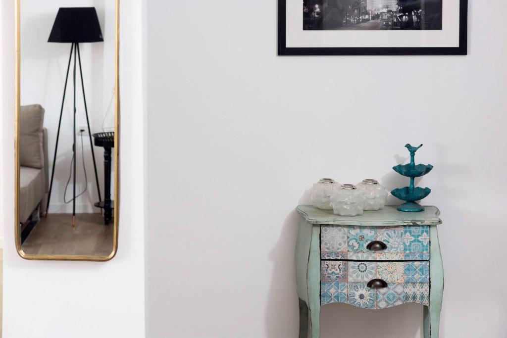 a side table next to a wall with a mirror at Modern & Bright 3BR Apt by Sea N' Rent in Tel Aviv